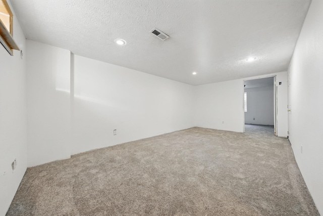 empty room featuring recessed lighting, visible vents, carpet, and a textured ceiling