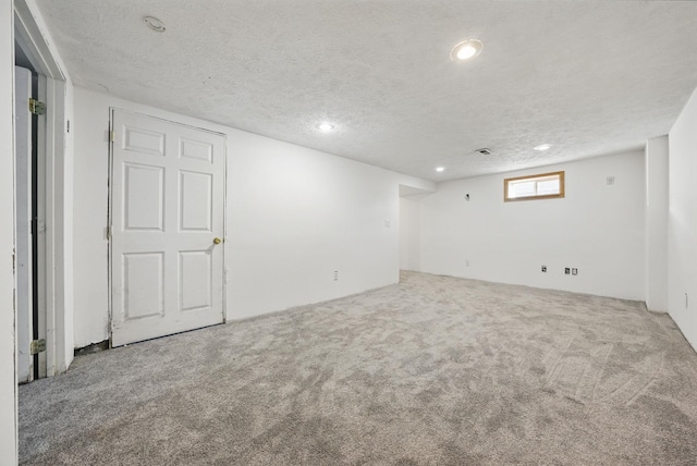 basement featuring carpet flooring, recessed lighting, and a textured ceiling