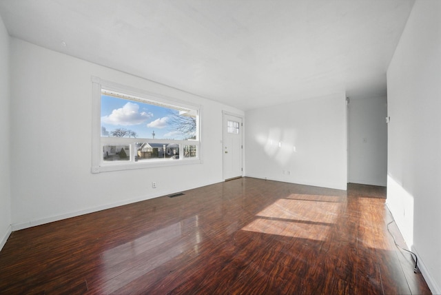 unfurnished living room with wood finished floors and visible vents