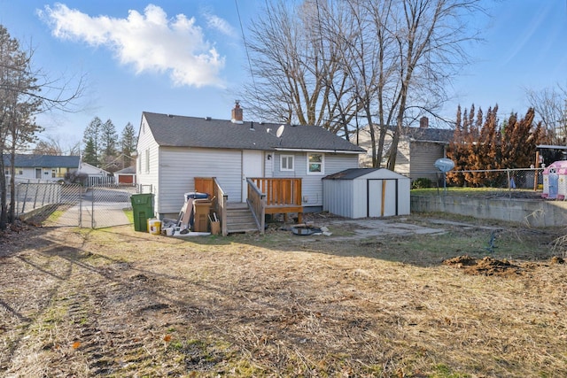 rear view of property with a deck, fence, a shed, an outdoor structure, and a chimney