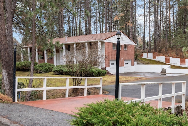 exterior space featuring a fenced front yard, concrete driveway, and a garage