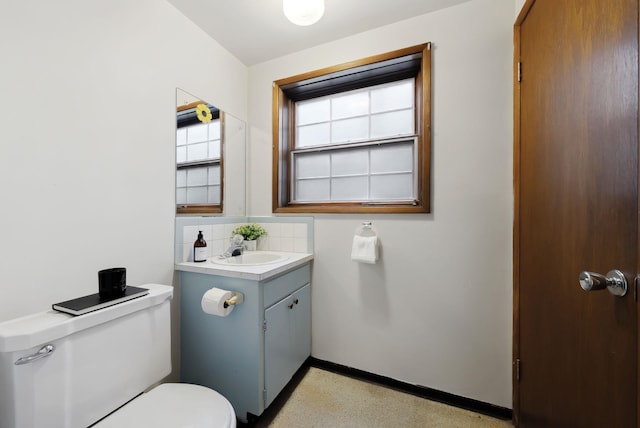 bathroom with baseboards, toilet, decorative backsplash, vanity, and speckled floor