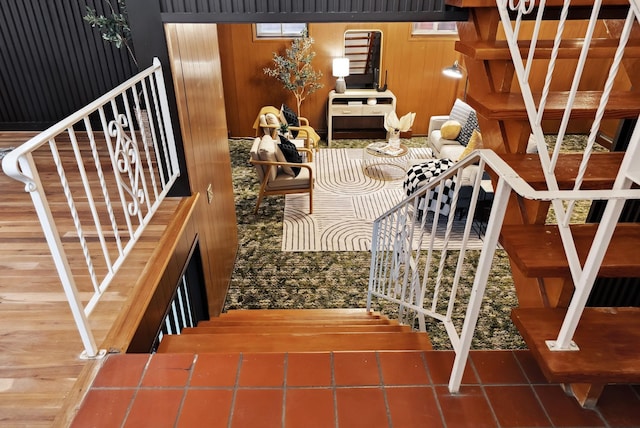 stairway featuring wooden walls