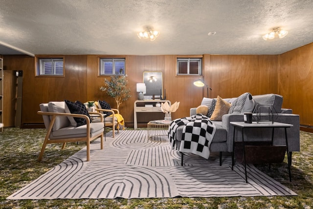 carpeted living area with wooden walls and a textured ceiling