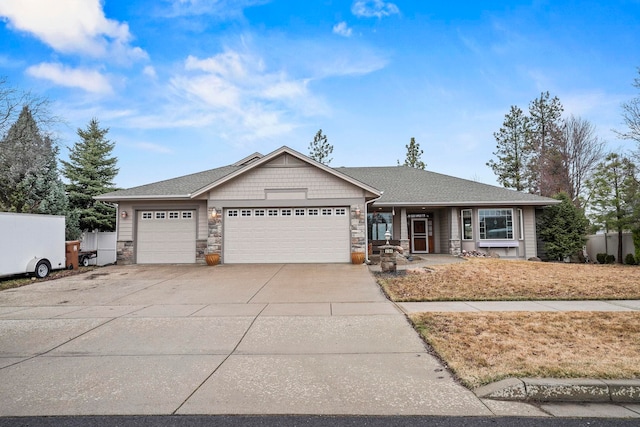 ranch-style house featuring an attached garage, fence, stone siding, and driveway