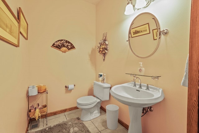 bathroom with tile patterned floors, toilet, and baseboards