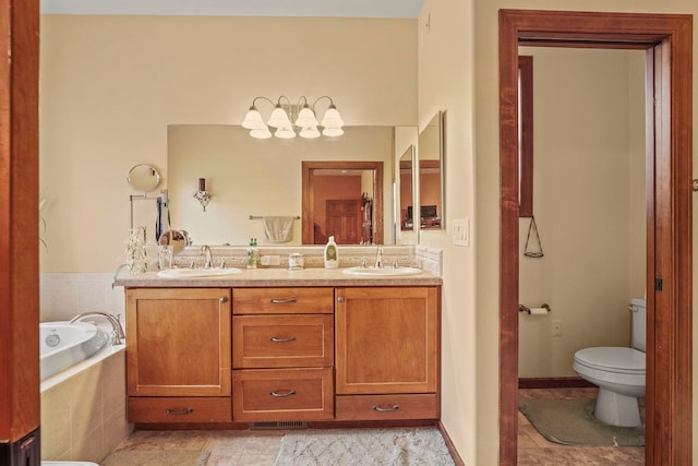 bathroom with a sink, a garden tub, toilet, and double vanity