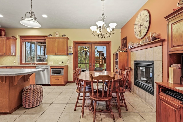 dining room featuring light tile patterned floors, recessed lighting, a tile fireplace, and an inviting chandelier