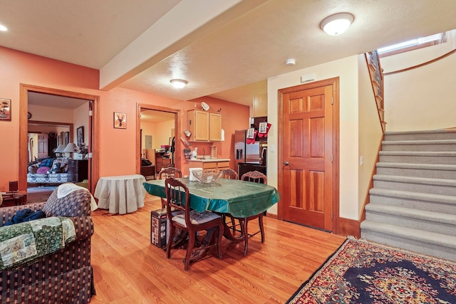 dining area with light wood-style flooring and stairs