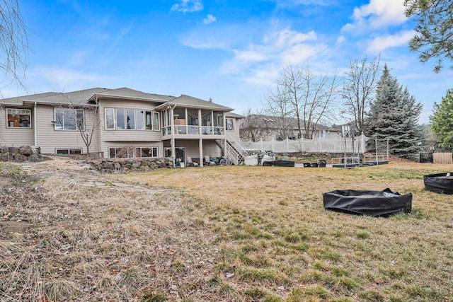 back of house with a yard, fence, and a sunroom