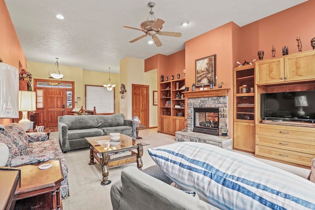 living room with a stone fireplace, recessed lighting, ceiling fan with notable chandelier, and light carpet