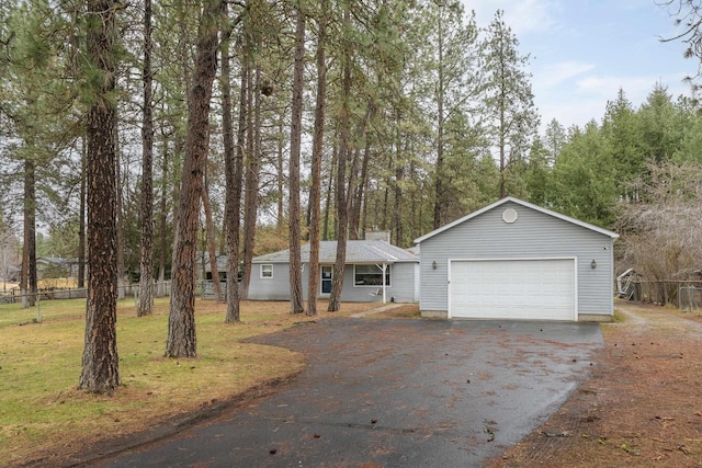 view of front of house featuring driveway, a front lawn, and fence