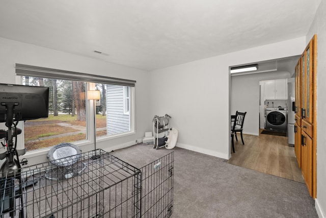 living room with carpet flooring, washer / clothes dryer, visible vents, and baseboards