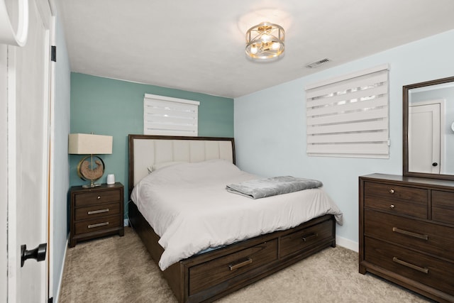 bedroom featuring visible vents, light carpet, and baseboards