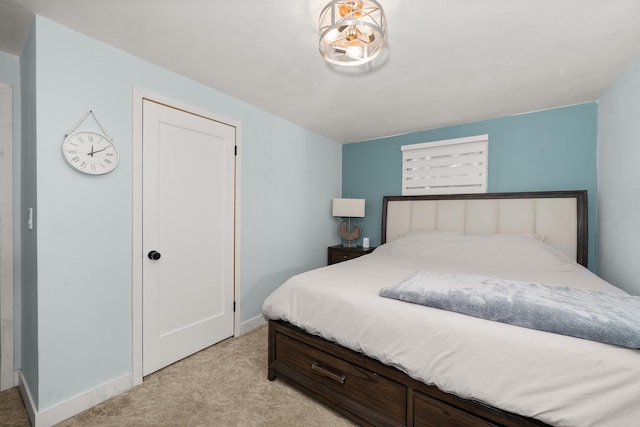 bedroom with light colored carpet and baseboards