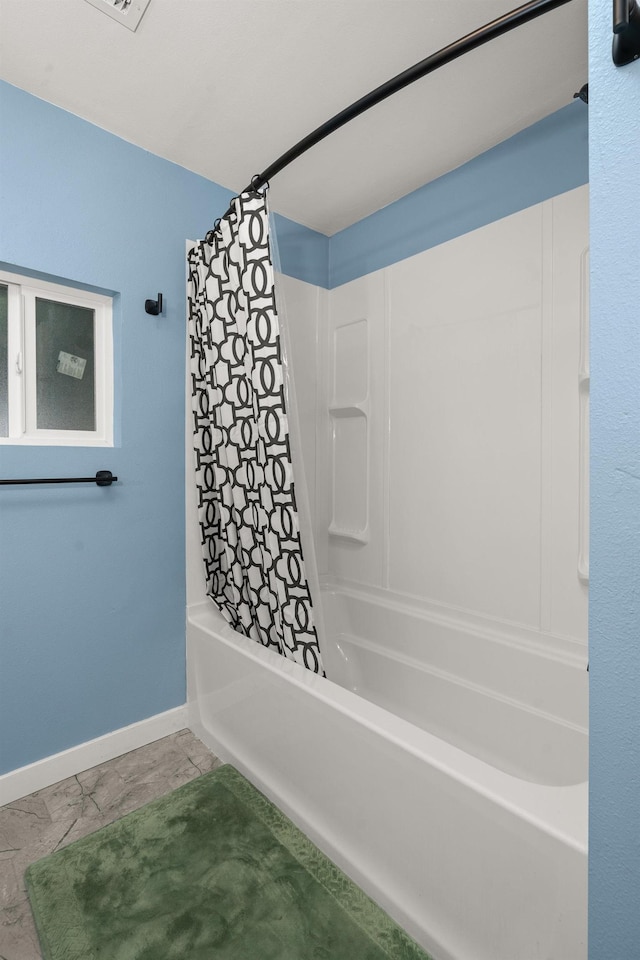 full bathroom with shower / bath combo with shower curtain and baseboards