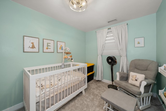 bedroom with a crib, carpet, visible vents, and baseboards