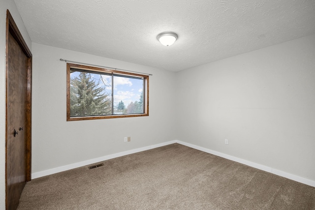 unfurnished bedroom with visible vents, a textured ceiling, baseboards, and carpet floors