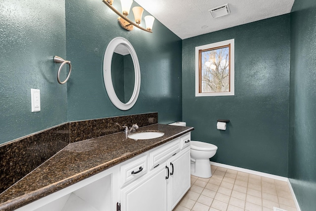 bathroom featuring vanity, baseboards, visible vents, a textured ceiling, and toilet