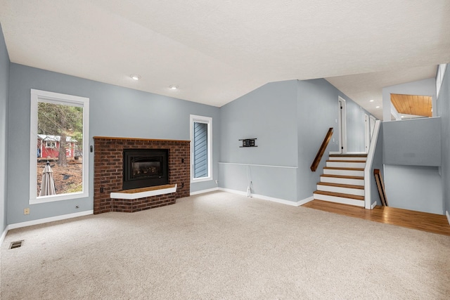 unfurnished living room featuring visible vents, carpet flooring, baseboards, and lofted ceiling