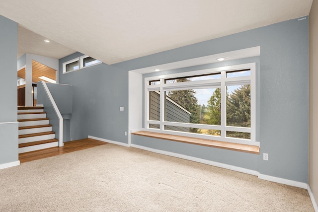 unfurnished living room featuring stairs, carpet flooring, recessed lighting, and baseboards