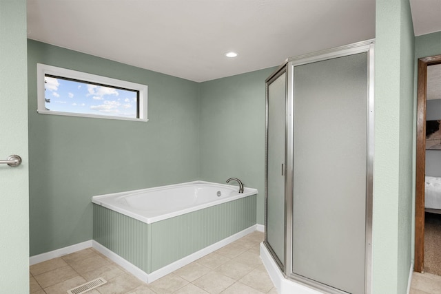 bathroom featuring tile patterned floors, visible vents, a shower stall, baseboards, and a bath