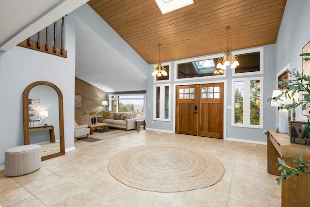 foyer entrance with wooden ceiling, a skylight, a notable chandelier, and high vaulted ceiling