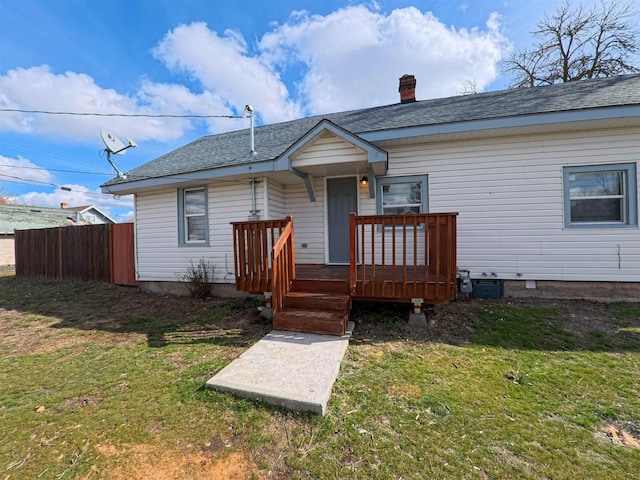 back of house featuring a yard, roof with shingles, and fence