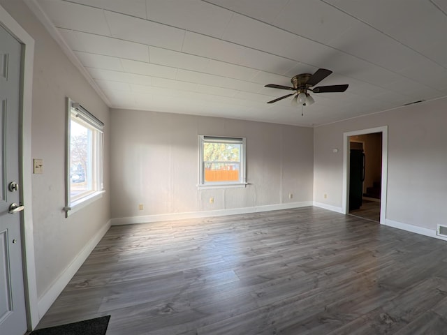 empty room featuring dark wood finished floors, visible vents, baseboards, and a ceiling fan