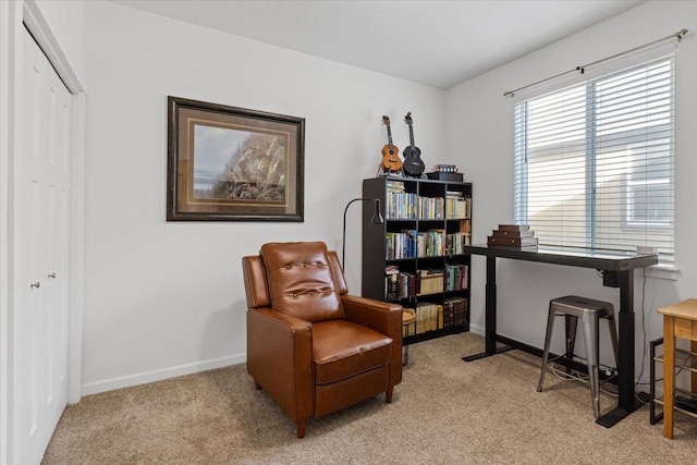 living area featuring light colored carpet and baseboards