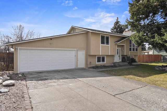 bi-level home with fence, a chimney, concrete driveway, a front lawn, and a garage