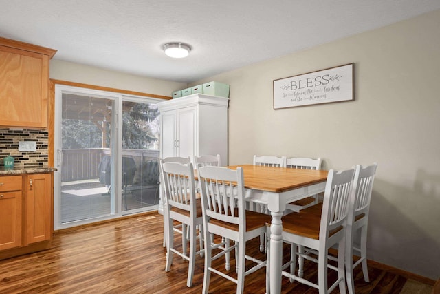 dining space featuring light wood finished floors and a textured ceiling