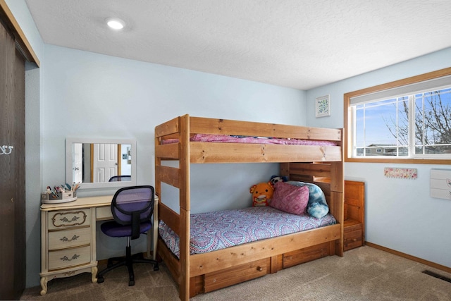 bedroom featuring baseboards, carpet, visible vents, and a textured ceiling