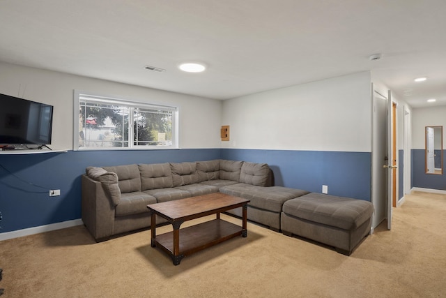 living room with baseboards, visible vents, and light carpet