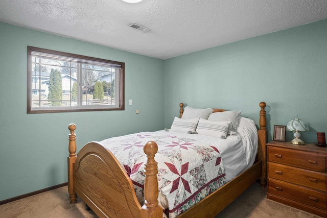 carpeted bedroom featuring baseboards, visible vents, and a textured ceiling