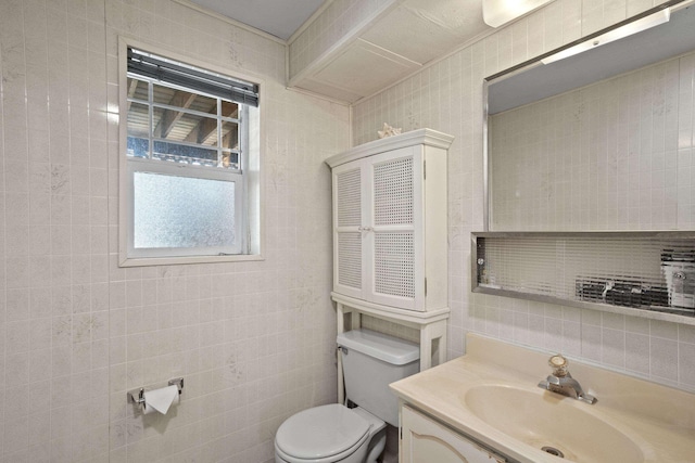 half bathroom featuring toilet, tile walls, and vanity