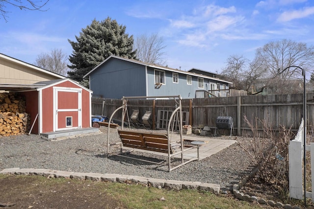 rear view of house featuring a fenced backyard, an outdoor structure, and a shed