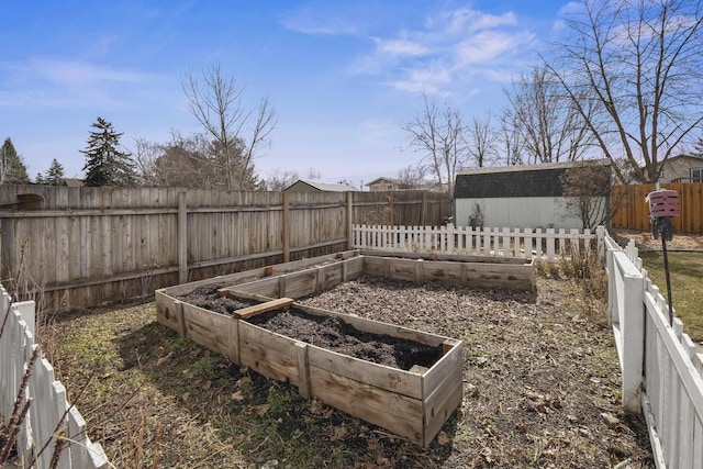 view of yard with an outbuilding, a fenced backyard, and a garden