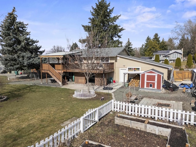 back of property with a storage unit, an outbuilding, a deck, a fenced backyard, and stairway