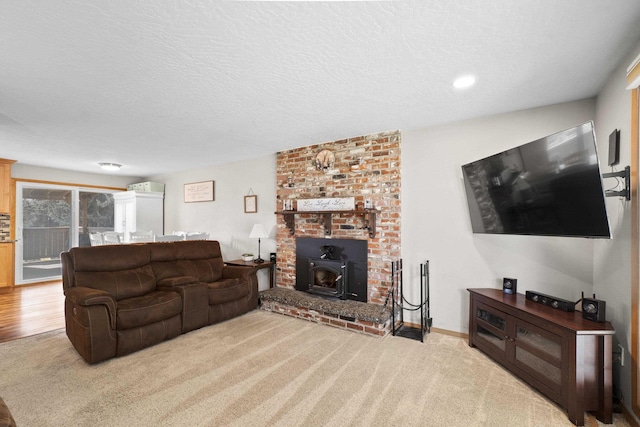 carpeted living area featuring a textured ceiling, a wood stove, and baseboards