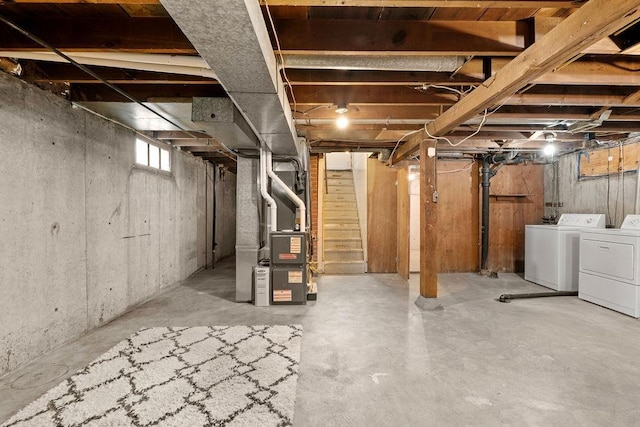 below grade area featuring stairs, heating unit, and independent washer and dryer