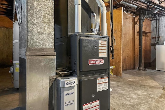 utility room with heating unit and washer / dryer