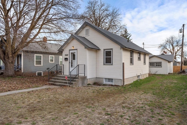 bungalow with metal roof and a front lawn