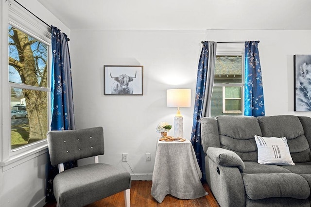 sitting room with a wealth of natural light, baseboards, and wood finished floors