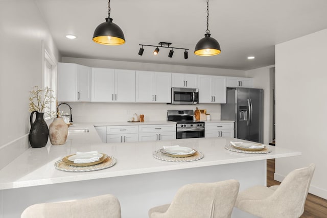 6712 C Highway 291, Nine Mile Falls, WA 99026 - kitchen featuring stainless steel appliances, a sink, a peninsula, light countertops, and a kitchen breakfast bar
