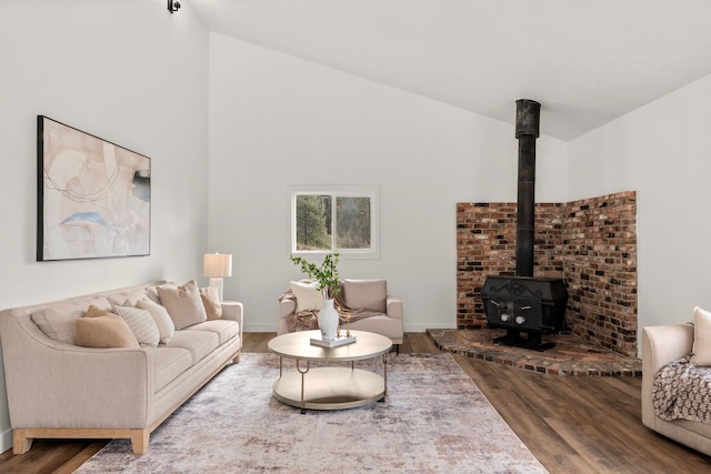 6712 C Highway 291, Nine Mile Falls, WA 99026 - living area featuring wood finished floors, a wood stove, lofted ceiling, and baseboards