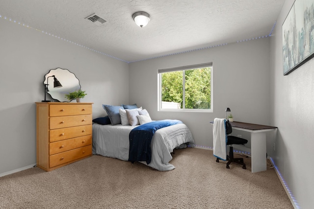 bedroom with visible vents, light carpet, a textured ceiling, and baseboards