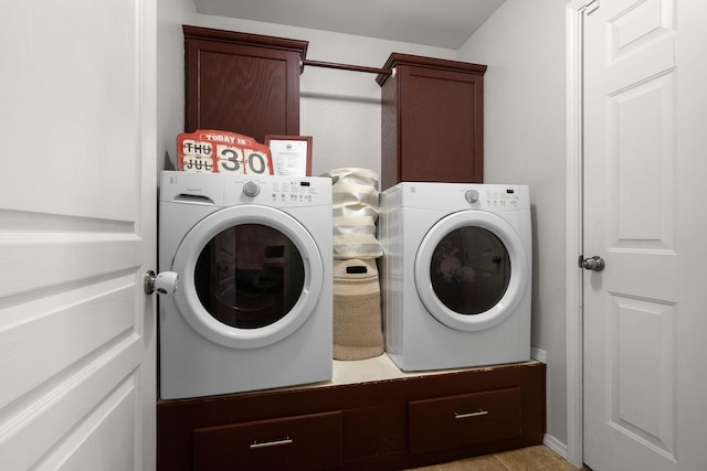 laundry room with cabinet space, light tile patterned flooring, and washing machine and dryer