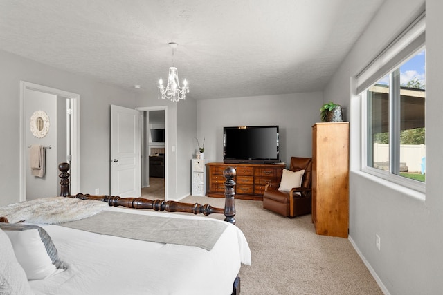 bedroom with a textured ceiling, baseboards, a chandelier, and light carpet