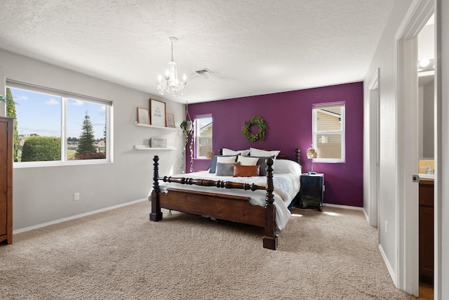 carpeted bedroom with baseboards, visible vents, a textured ceiling, and an inviting chandelier